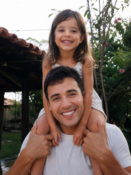 Pai com a filha nos ombros